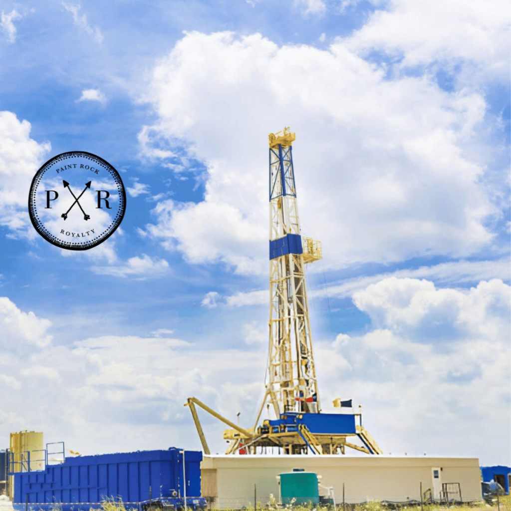 Modern oil drilling rig under a bright blue sky with the PXR logo.