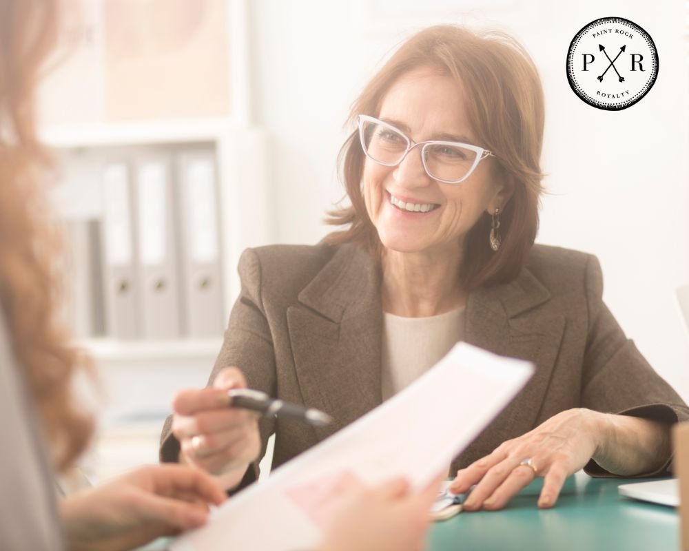 Smiling professional woman handing documents during a meeting.