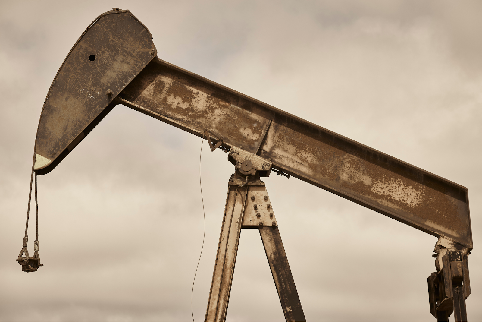 Close-up of a rusted oil pumpjack arm with worn-out metal structure.