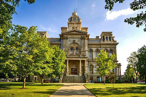 Grand historic courthouse with ornate architecture, clock tower, and lush green landscaping.